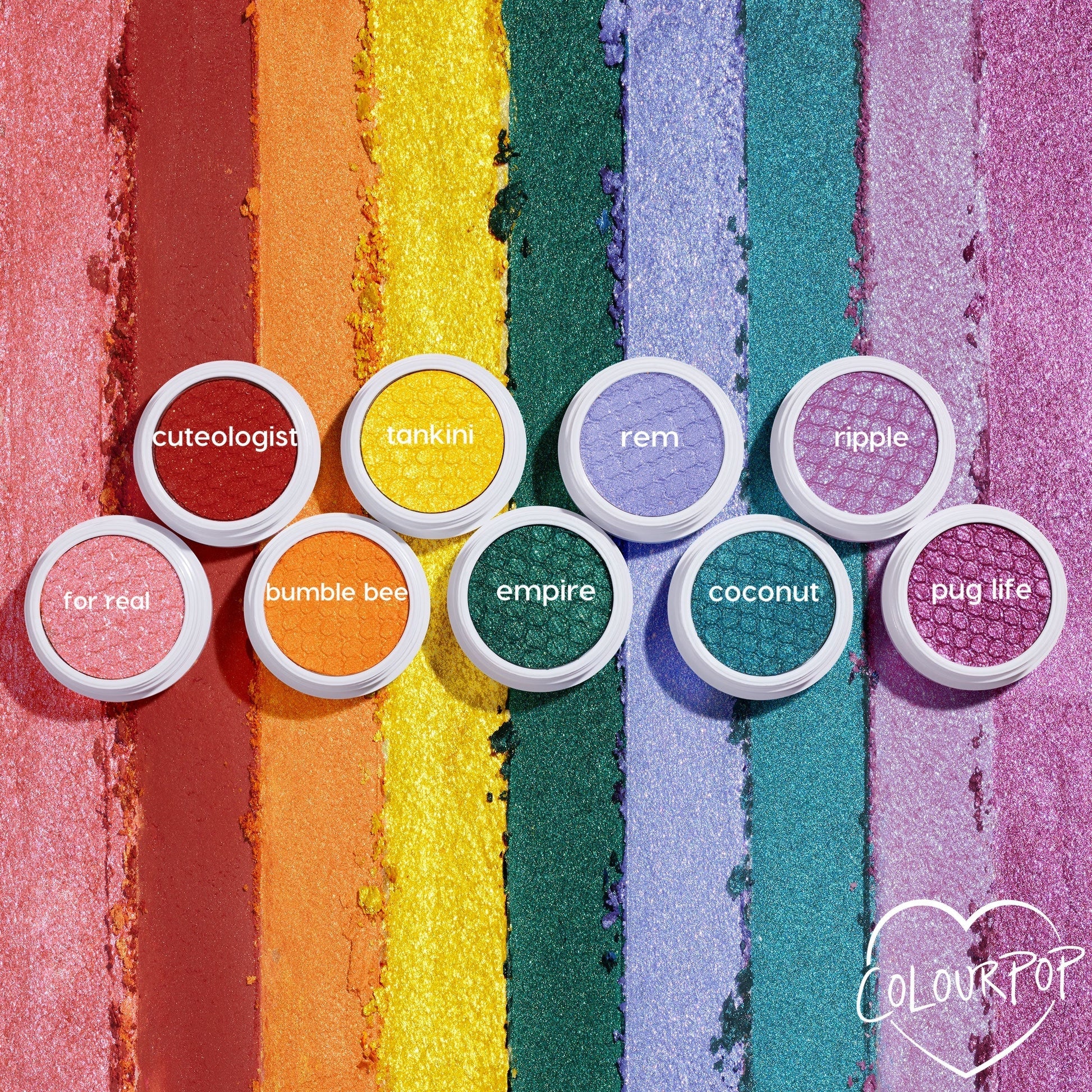 Empire Super Shock Shadow by ColourPop glows as a metallic emerald single in a white pot, centered on a flat lay of rainbow shimmer swatches and companion shades, showcasing rich green payoff and bouncy cream-to-powder texture.