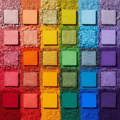 Fade Into Hue shadow palette displays 30 square pans in a rainbow grid - matte, shimmer, and pressed glitter - set on crushed pigment in a deconstructed flat lay; a vibrant ColourPop Shadow Palette.