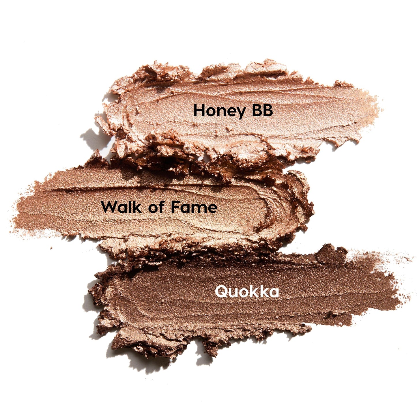 ColourPop Shadow Stix Shimmering Golds swatches display three creamy metallic strokes on a white background - Honey BB (champagne), Walk of Fame (warm gold), and Quokka (deep bronze) - smeared to showcase shimmer and blendable payoff.