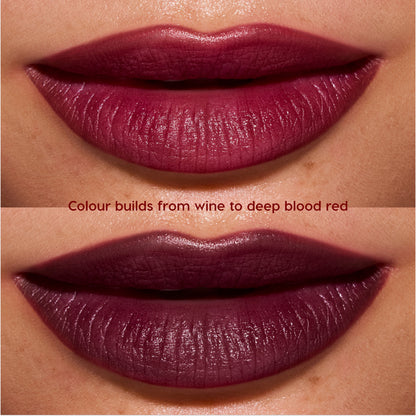 Close-up lips wearing Newborn powder to creme lipstick from the Twilight collection, showing buildable color shifting from rich wine to deep blood-red with a smooth, satin finish on medium skin tone.
