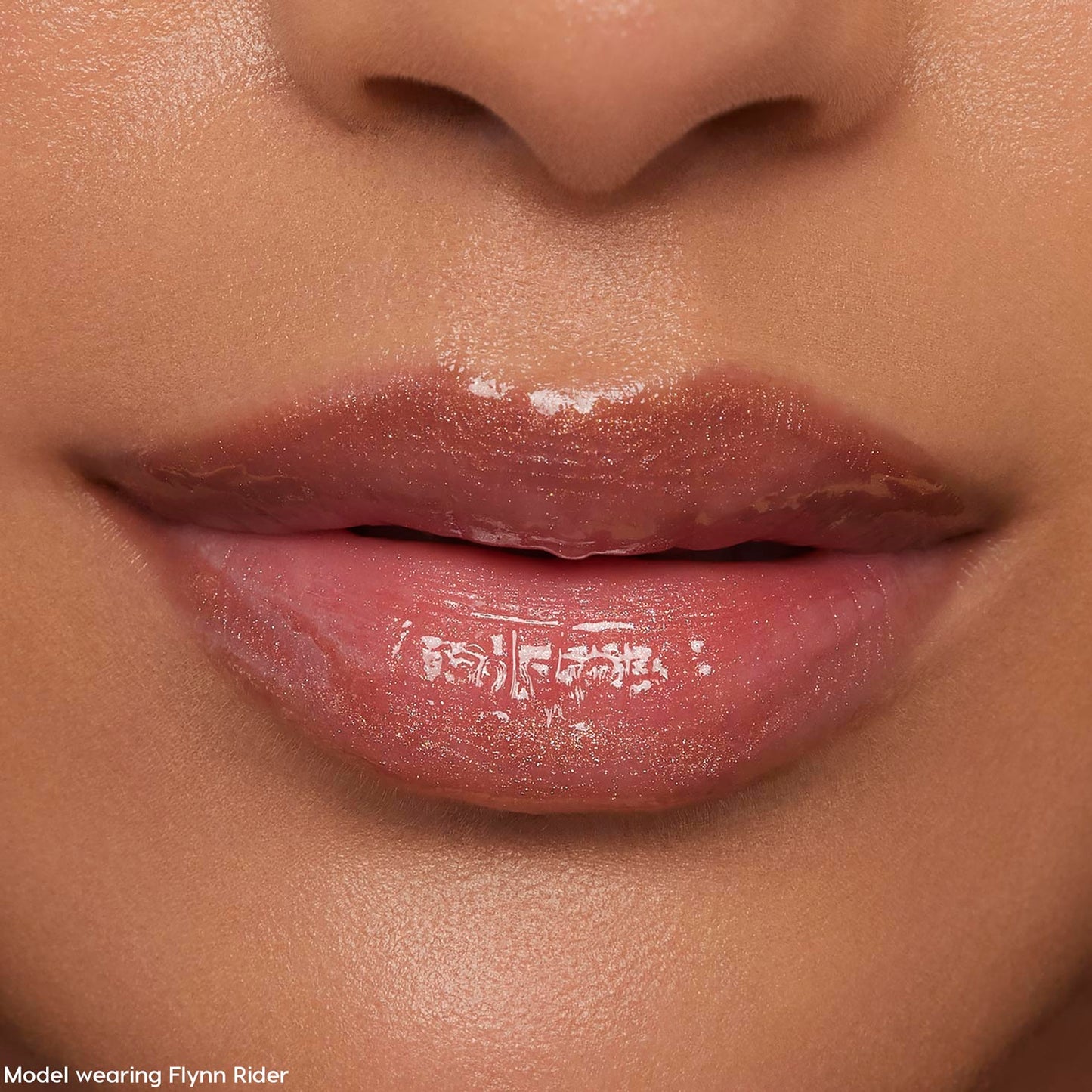 Glossy nude-pink lips wearing ColourPop Ultra Glossy Lip in Flynn Rider, reflecting a high-shine finish with subtle shimmer in a tight face close-up, showcasing smooth, hydrated texture for everyday wear.